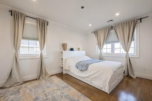 bedroom featuring baseboards, visible vents, dark wood-style floors, ornamental molding, and recessed lighting