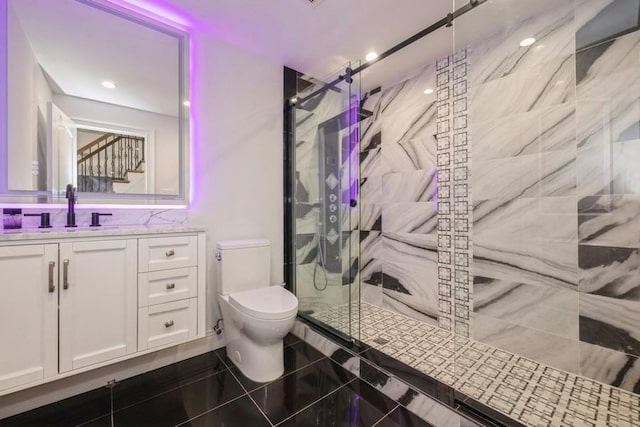 full bath featuring toilet, tile patterned flooring, a marble finish shower, and vanity