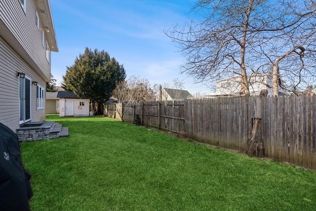 view of yard featuring an outbuilding, a fenced backyard, and a shed