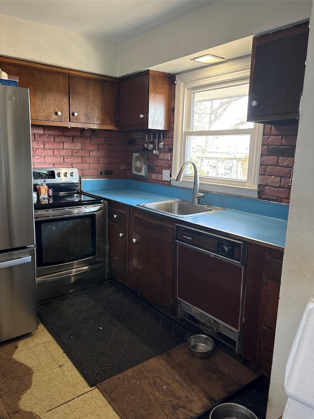 kitchen with light countertops, appliances with stainless steel finishes, light floors, and a sink