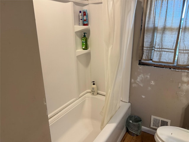 bathroom with shower / tub combo, baseboards, visible vents, and toilet