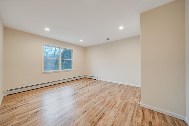 empty room featuring light wood-type flooring, baseboards, baseboard heating, and recessed lighting