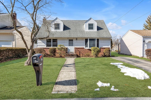 cape cod home with brick siding, a front lawn, central AC unit, and a shingled roof