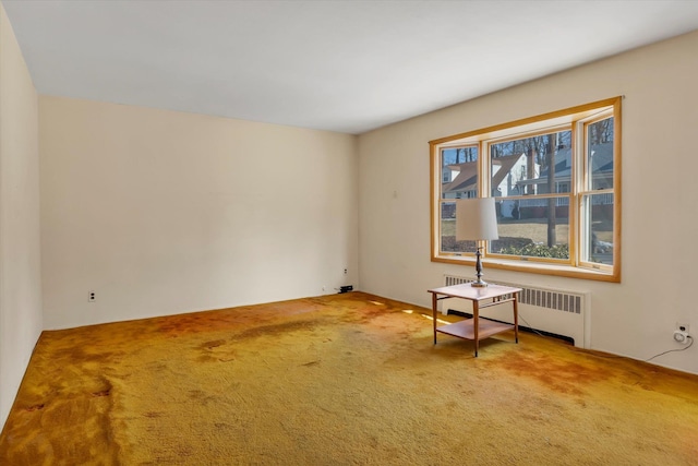 carpeted empty room featuring radiator