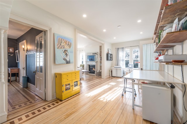 kitchen with decorative columns, light wood-type flooring, a fireplace, open shelves, and recessed lighting