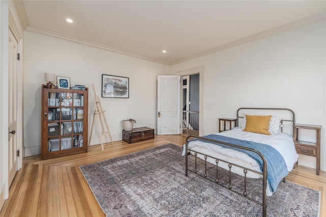 bedroom featuring ornamental molding, wood finished floors, and recessed lighting