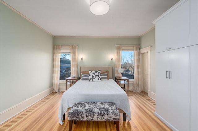 bedroom with baseboards, ornamental molding, and light wood-style floors