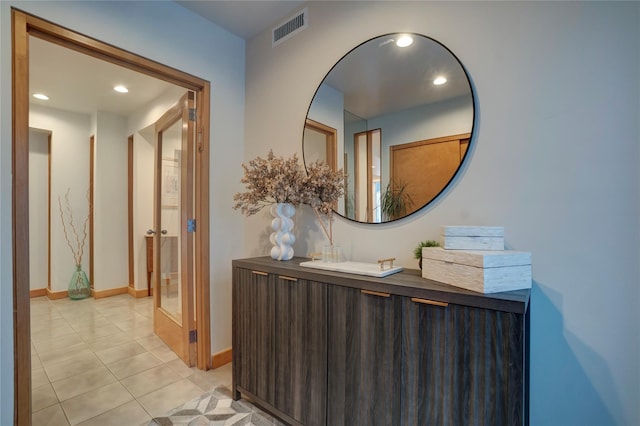 corridor with recessed lighting, visible vents, baseboards, and light tile patterned floors