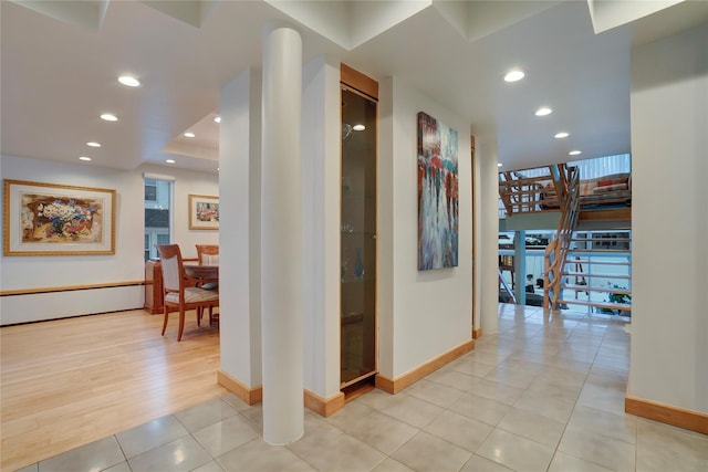 corridor featuring baseboards, stairway, light tile patterned flooring, and recessed lighting