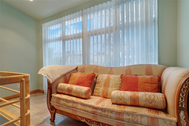 living area with tile patterned flooring, baseboards, and vaulted ceiling