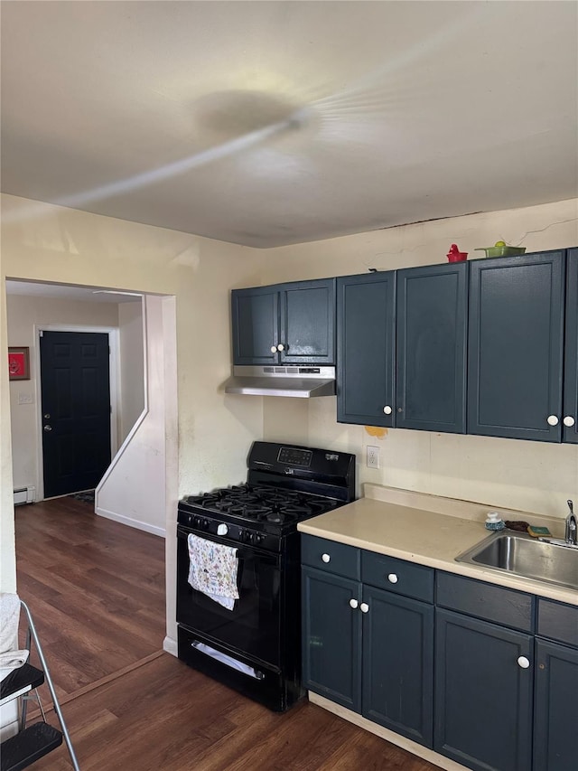 kitchen with under cabinet range hood, a sink, light countertops, dark wood-style floors, and gas stove