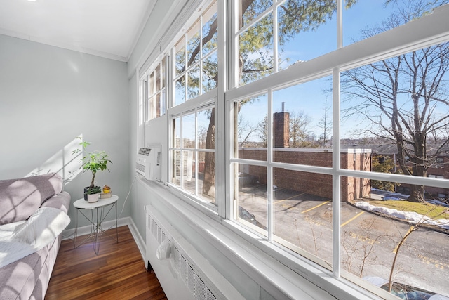 living area featuring baseboards, wood finished floors, and crown molding