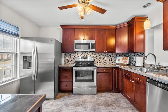 kitchen featuring decorative light fixtures, decorative backsplash, stainless steel appliances, and a sink