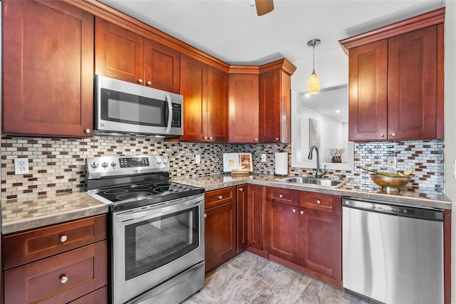 kitchen with a sink, stainless steel appliances, light countertops, decorative light fixtures, and backsplash