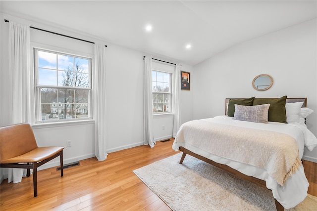 bedroom with visible vents, lofted ceiling, recessed lighting, light wood-style floors, and baseboards