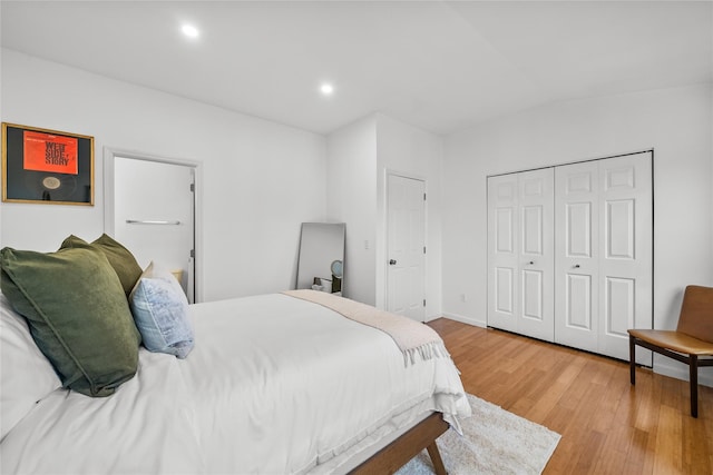 bedroom with recessed lighting, a closet, light wood finished floors, and baseboards