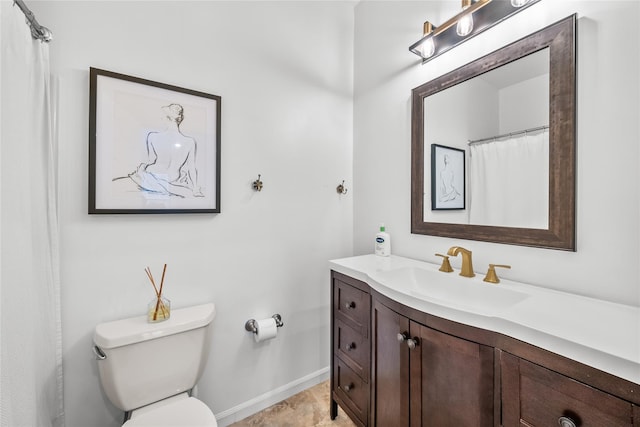 bathroom featuring toilet, vanity, and baseboards