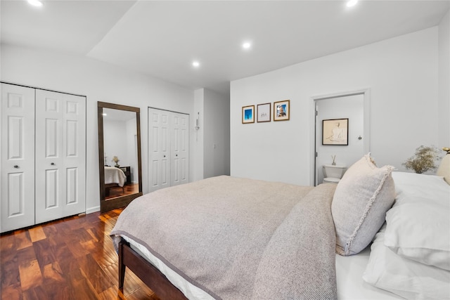 bedroom featuring dark wood finished floors, recessed lighting, and two closets