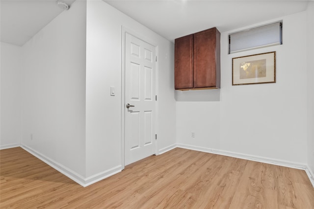 interior space with baseboards and light wood finished floors