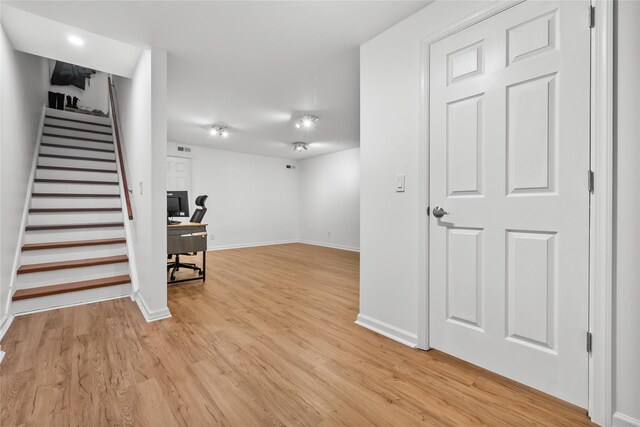 interior space featuring stairs, baseboards, and light wood-type flooring