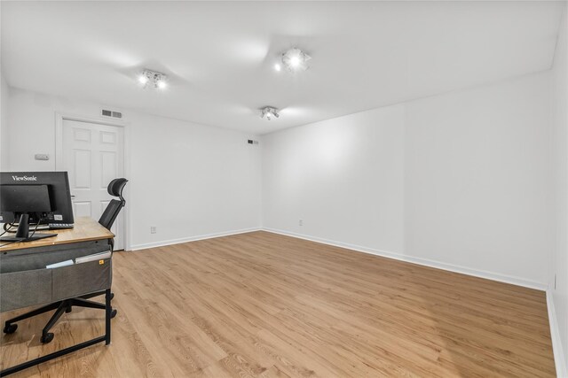 office with baseboards, visible vents, and light wood finished floors