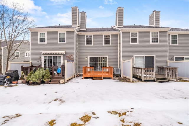 snow covered house with a deck