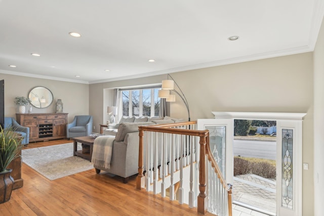 living area with ornamental molding, wood finished floors, and recessed lighting