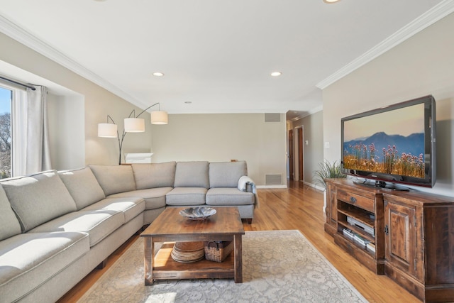 living room with light wood-style floors, visible vents, and ornamental molding