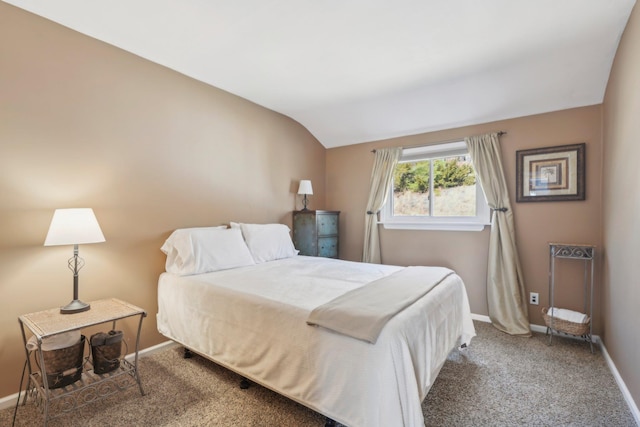 carpeted bedroom with lofted ceiling and baseboards