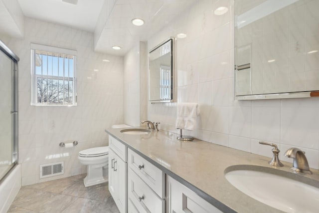 bathroom with tile walls and a sink