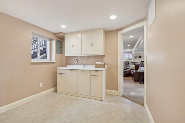 kitchen with recessed lighting, baseboards, light countertops, electric panel, and light floors