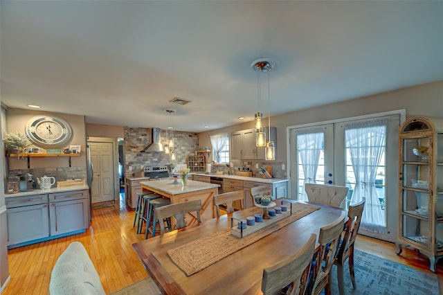 dining area with french doors, light wood-type flooring, visible vents, and recessed lighting