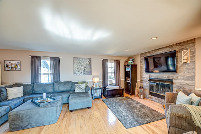 living area with plenty of natural light, a fireplace, and wood finished floors