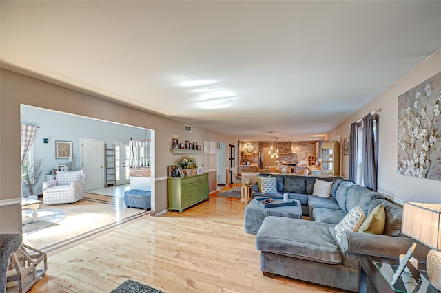 living room with visible vents and light wood-style flooring