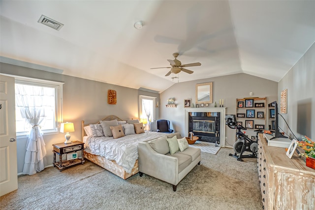 bedroom featuring vaulted ceiling, a fireplace, visible vents, and light colored carpet