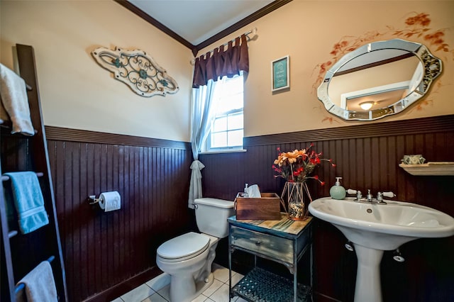 bathroom with toilet, a wainscoted wall, crown molding, and tile patterned floors