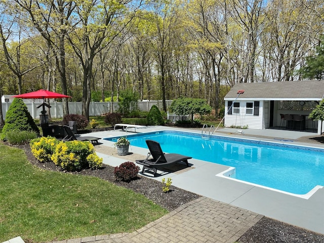 view of pool featuring an exterior structure, a patio area, fence, an outdoor structure, and a diving board