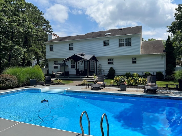 outdoor pool with a fire pit and a patio