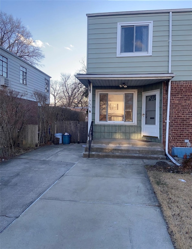 view of front of home with brick siding and fence