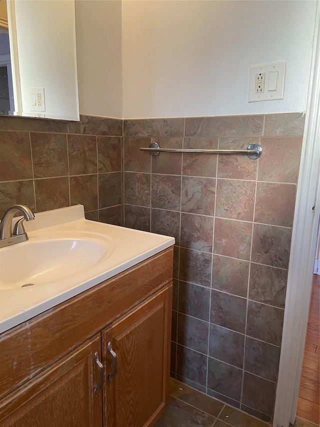 bathroom featuring tile walls, a wainscoted wall, and vanity