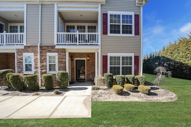 view of front of property with a front yard and stone siding