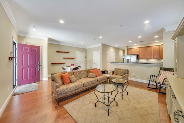 living room with recessed lighting, crown molding, and light wood-style flooring