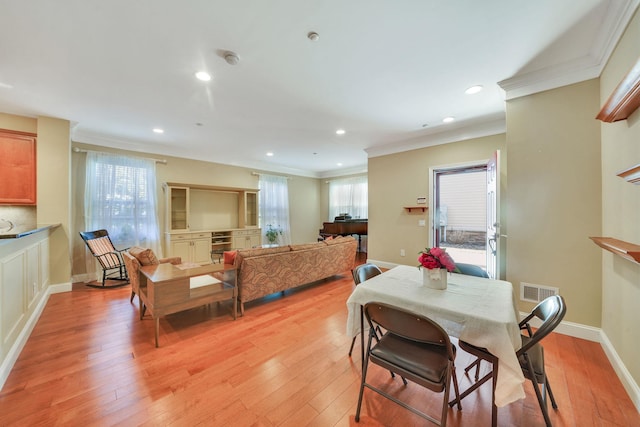 dining space with light wood-style floors, baseboards, crown molding, and recessed lighting