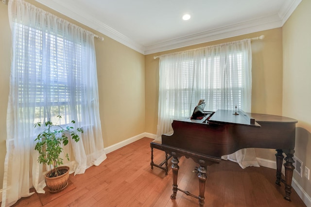 sitting room with light wood finished floors, baseboards, and ornamental molding