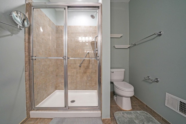 full bath featuring tile patterned flooring, toilet, visible vents, baseboards, and a stall shower