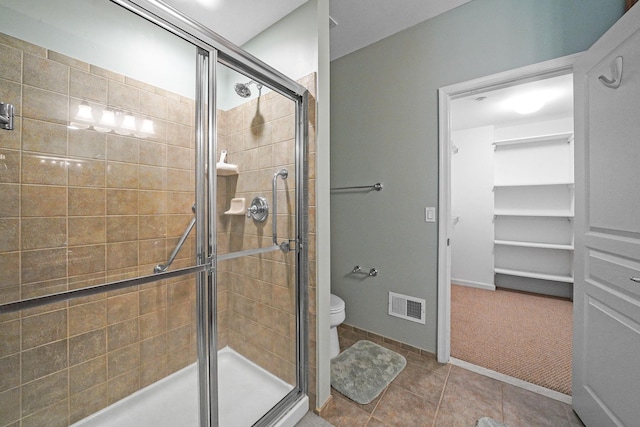 full bathroom with a stall shower, visible vents, a spacious closet, and toilet