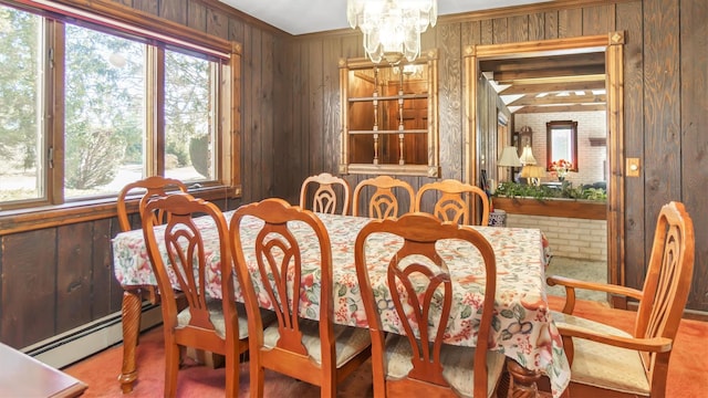 155 Shepard Dr, Southold, NY 11971 - dining space featuring crown molding, a baseboard heating unit, wood walls, and an inviting chandelier