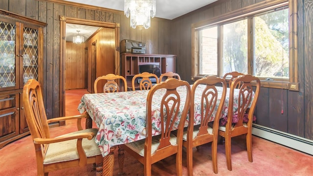 155 Shepard Dr, Southold, NY 11971 - carpeted dining area with wood walls, a chandelier, a baseboard heating unit, and ornamental molding