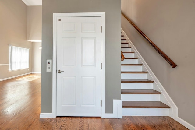 stairs featuring wood finished floors and baseboards