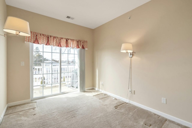 carpeted spare room with baseboards and visible vents